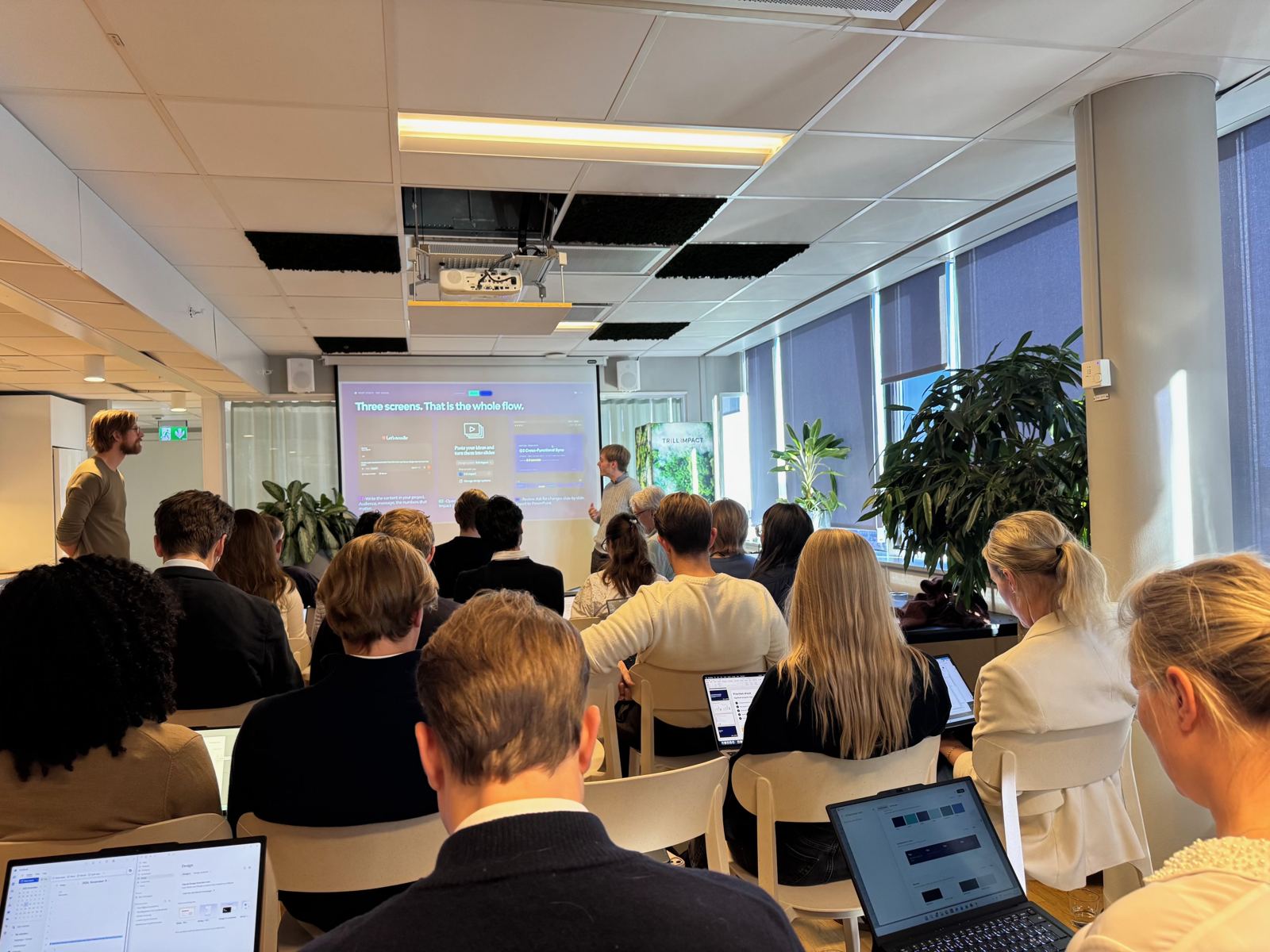 Deltagare med laptops följer en genomgång av ett arbetsflöde på projektorduk
